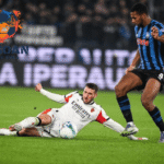 Pemain bertahan melakukan tekel untuk merebut bola dalam pertandingan Liga Italia, dengan logo Jagoan Super Bola di latar gambar.