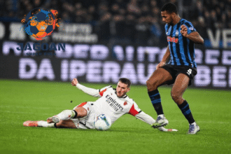 Pemain bertahan melakukan tekel untuk merebut bola dalam pertandingan Liga Italia, dengan logo Jagoan Super Bola di latar gambar.