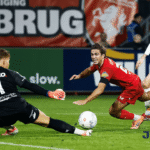 Kiper melakukan penyelamatan penting saat pemain lawan berusaha mencetak gol dalam pertandingan sepak bola Eredivisie