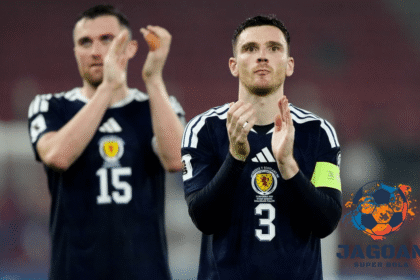 Dua pemain tim nasional Skotlandia mengenakan jersey biru memberikan tepuk tangan di lapangan setelah pertandingan.