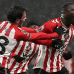 Dua pemain Sunderland melakukan selebrasi gol di tengah hujan dengan seragam merah-putih selama laga Liga Inggris.