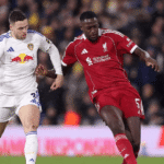 Dua pemain Leeds United dan Liverpool berebut bola dalam pertandingan sepak bola Liga Inggris.