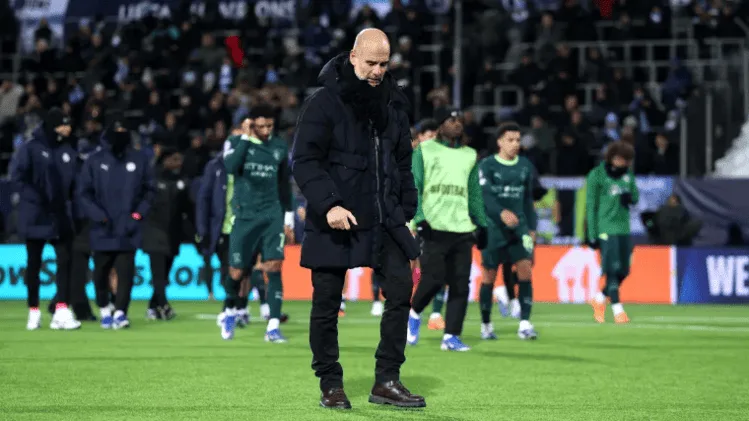 Pep Guardiola berjalan di lapangan usai pertandingan Liga Champions bersama pemain Manchester City