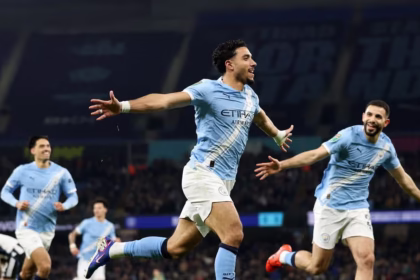 Pemain Manchester City dengan seragam biru langit merayakan kemenangan skor 3-1 melawan Newcastle United dengan mengangkat tangan di tengah lapangan.