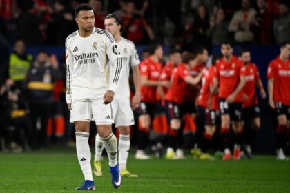 Pemain Real Madrid tertunduk dengan seragam putih Emirates Fly Better sementara para pemain Osasuna berbaju merah merayakan gol pada laga La Liga